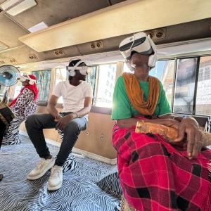 3 visitors sit with VR glasses in the Daladala (bus).