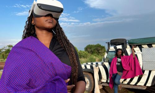 2 people on a safari, 1 in the back and 1 with a VR glass